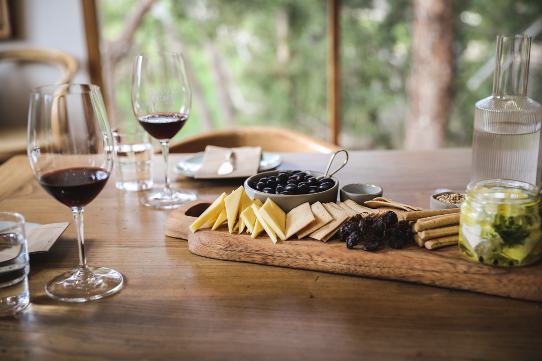 Wine glasses with wine and cheese plate on a table